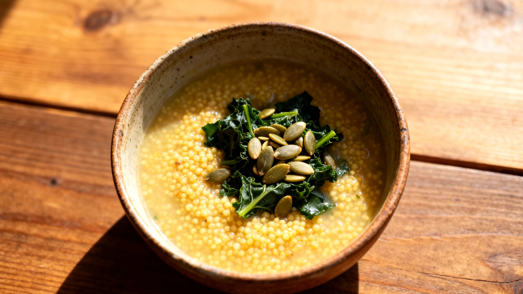 Zuppa di miglio con verdure amare e semi di zucca"